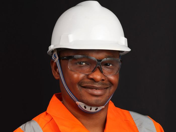Trabajador de construcción sonriendo con casco y gafas de seguridad