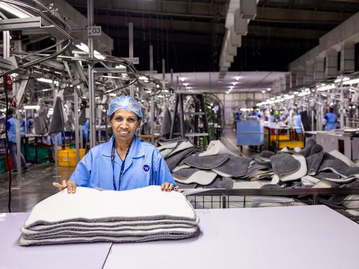 Trabajadora sonriendo en una planta de manufactura textil